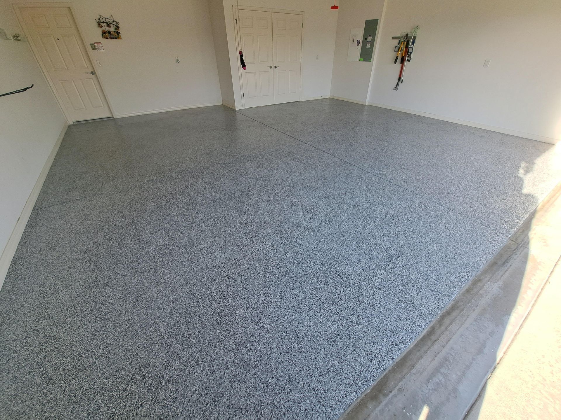 A garage with a gray floor and white walls.
