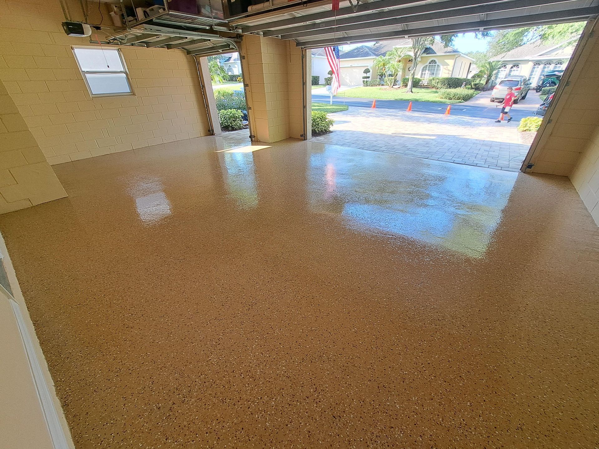 A garage with a shiny floor and a garage door open.