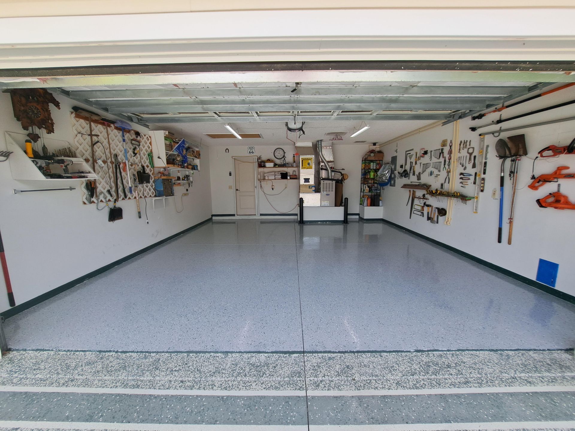 A garage with a lot of tools on the wall and floor.