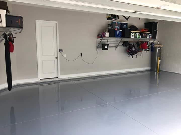A garage with a gray floor and a white door.
