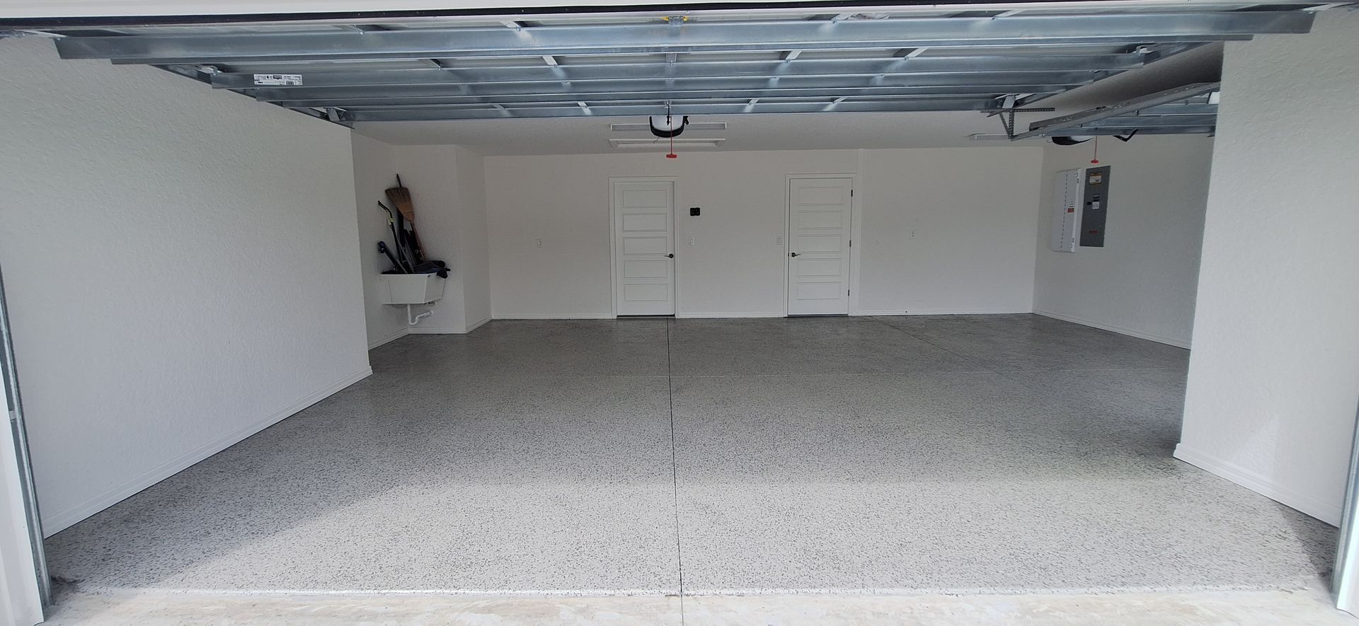 A garage with a gray concrete floor and white walls.