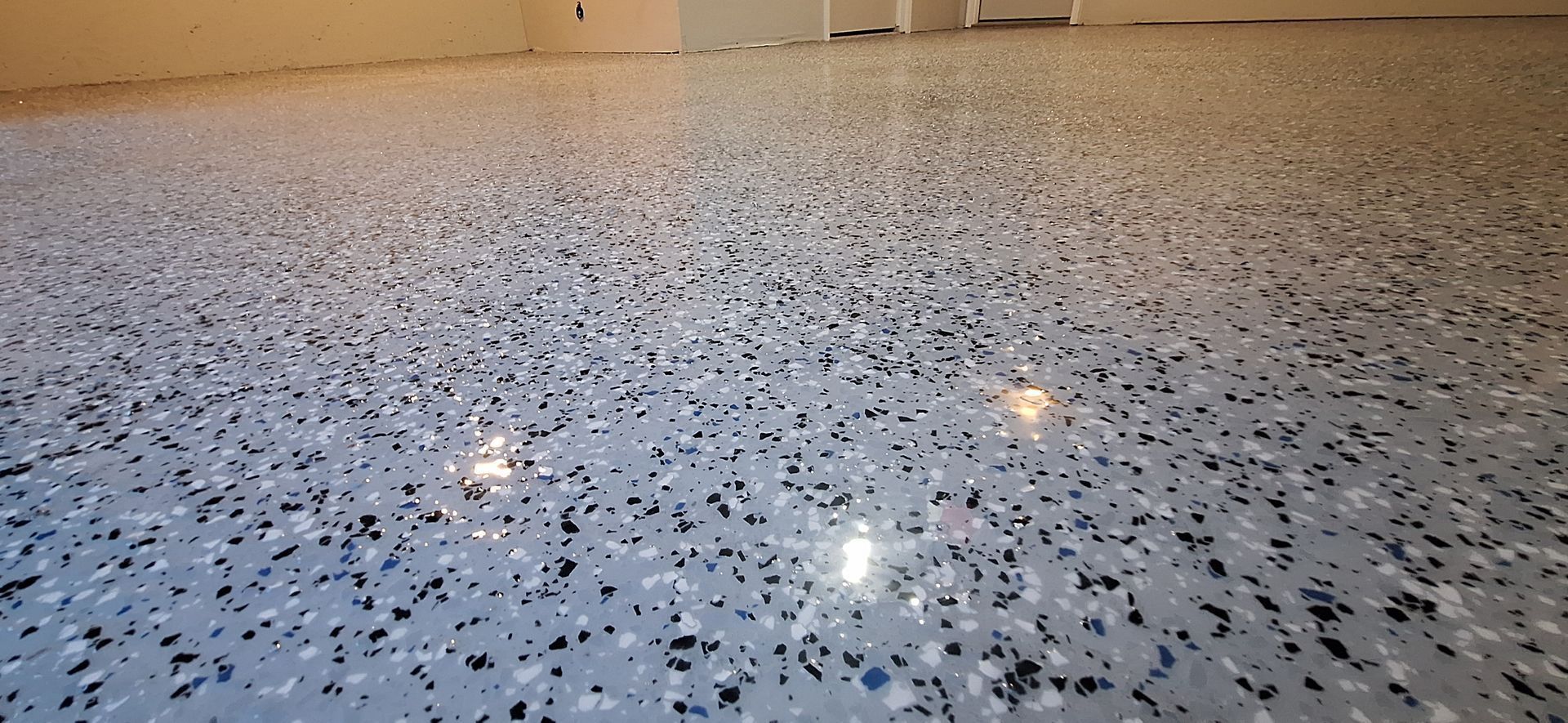 A close up of a shiny gray and black floor in a garage.