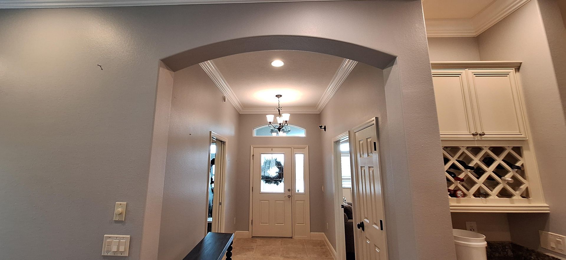 A hallway in a house with a wine rack on the wall.