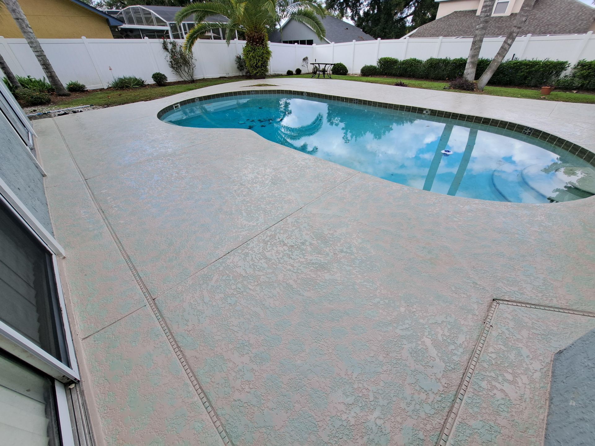 There is a large swimming pool in the backyard of a house.