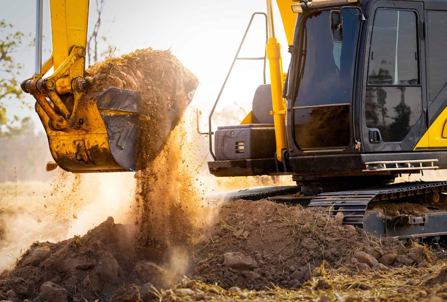 A Yellow Excavator is Digging a Hole in a Dirt Field — Ensbey Earthmoving in Glenview, QLD