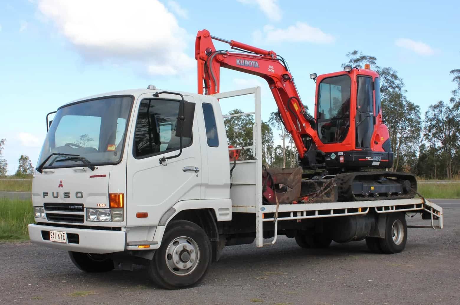 A White Fuso Truck With a Red Excavator on the Back — Ensbey Earthmoving in Glenview, QLD