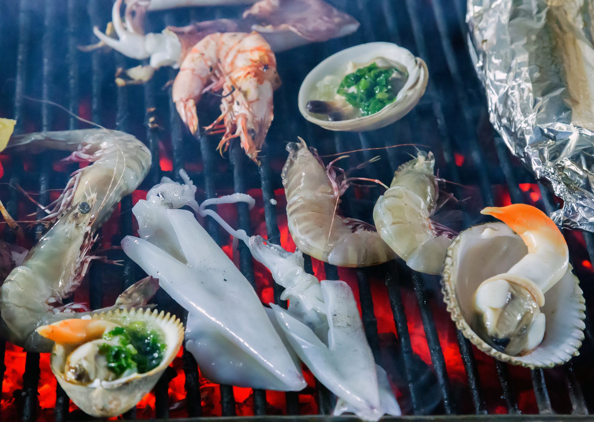 Fresh seafood display with fish, shrimp, lemon wedges, and ice on a market tray