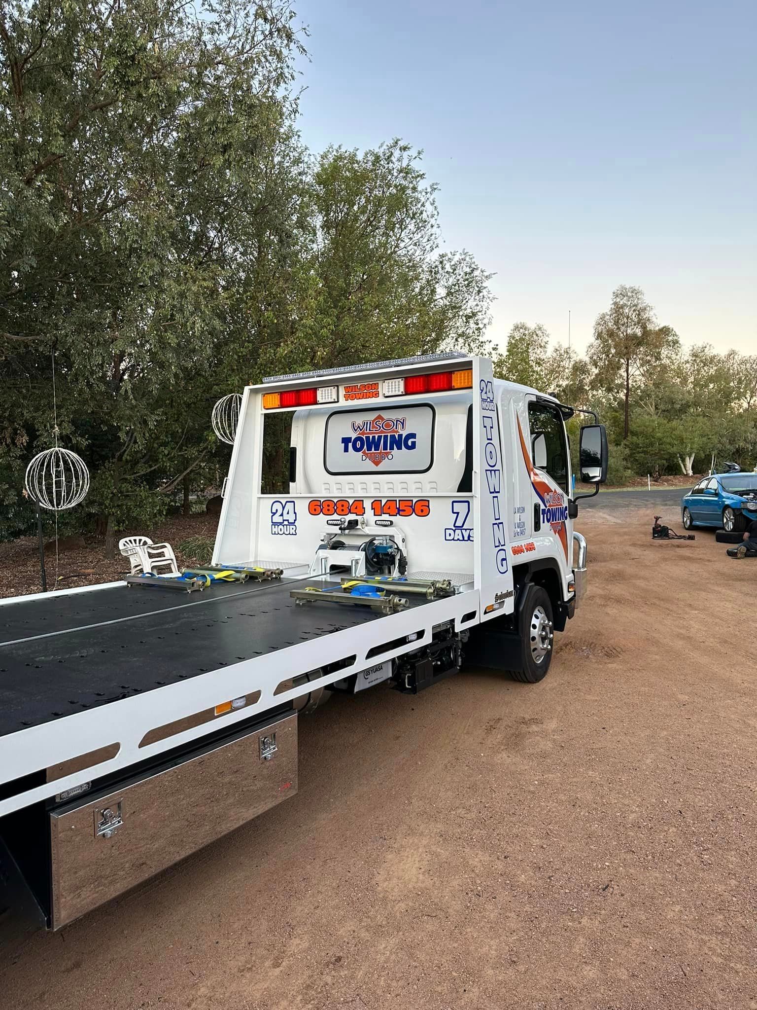 Red Broken Car on a Red Towing Truck — Tow in Dubbo, NSW