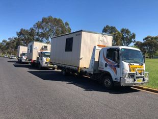 Truck driver standing by container truck — Tow in Dubbo, NSW
