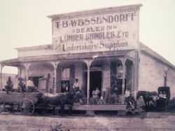 Old storefront with sign for T.B. Wessendorff, dealer in lumber, shingles, and undertaker’s supplies