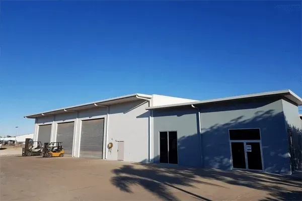 Exterior of a Large Gray Industrial Building With Garage Doors— Griffin Distributors In Mount St John, QLD