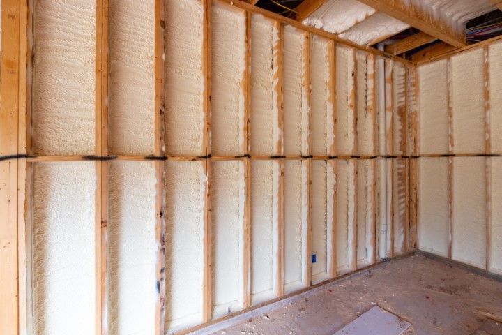 Insulated unfinished room with exposed framing and spray foam on the walls and ceiling