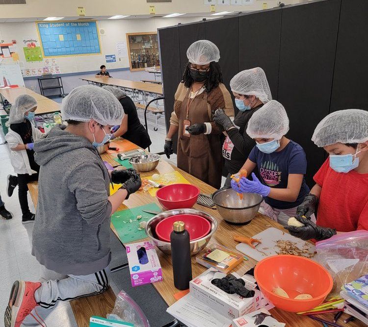 Students prepare a recipe with guidance from their instructors.