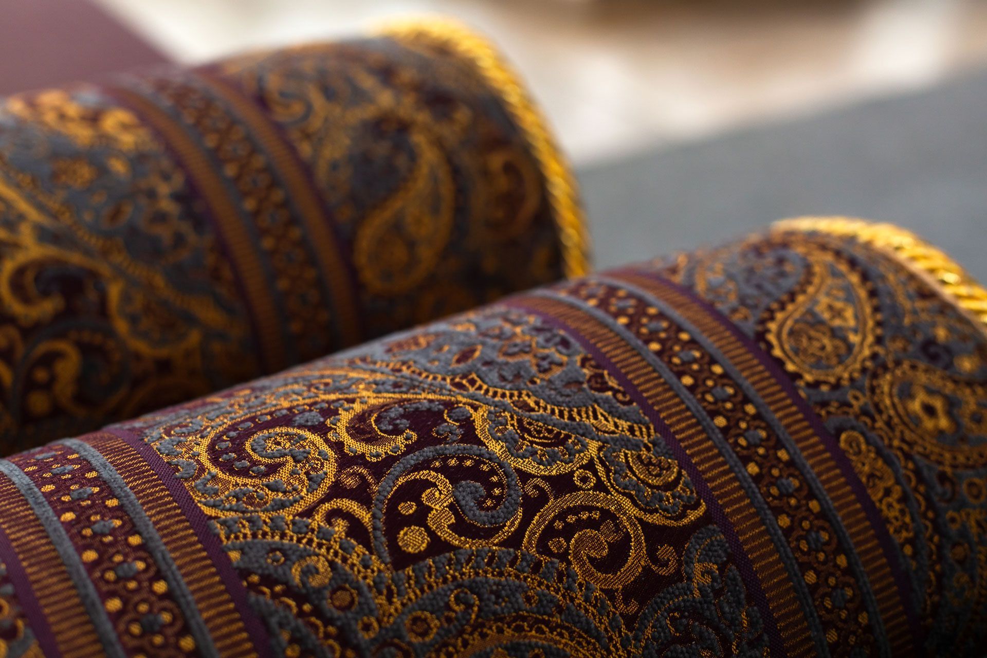 Close-up of two ornate rolled rugs with gold and brown patterns