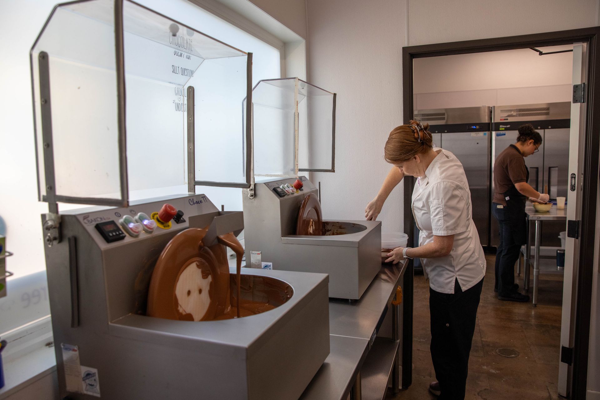 People viewing a display of decorative mechanical devices in a bright gallery space