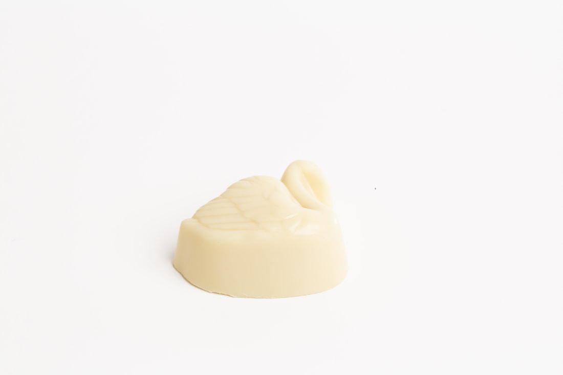 Small ivory-colored sculpted object on a plain white background