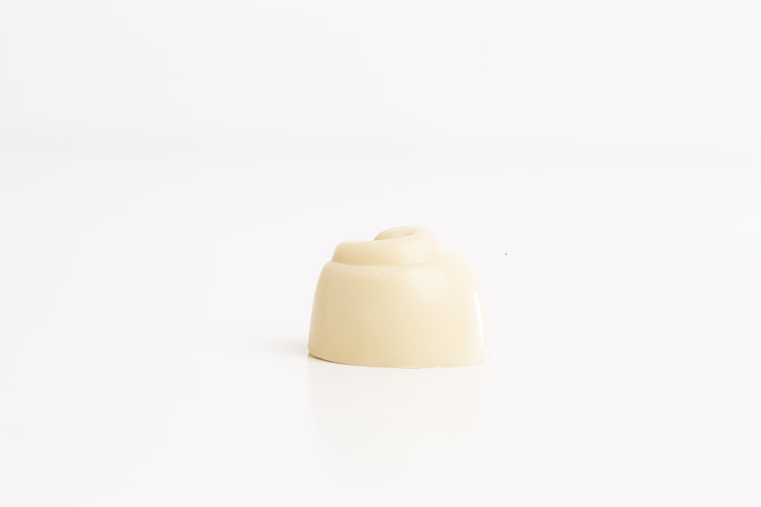 Small cream-colored dome-shaped dessert on a white background