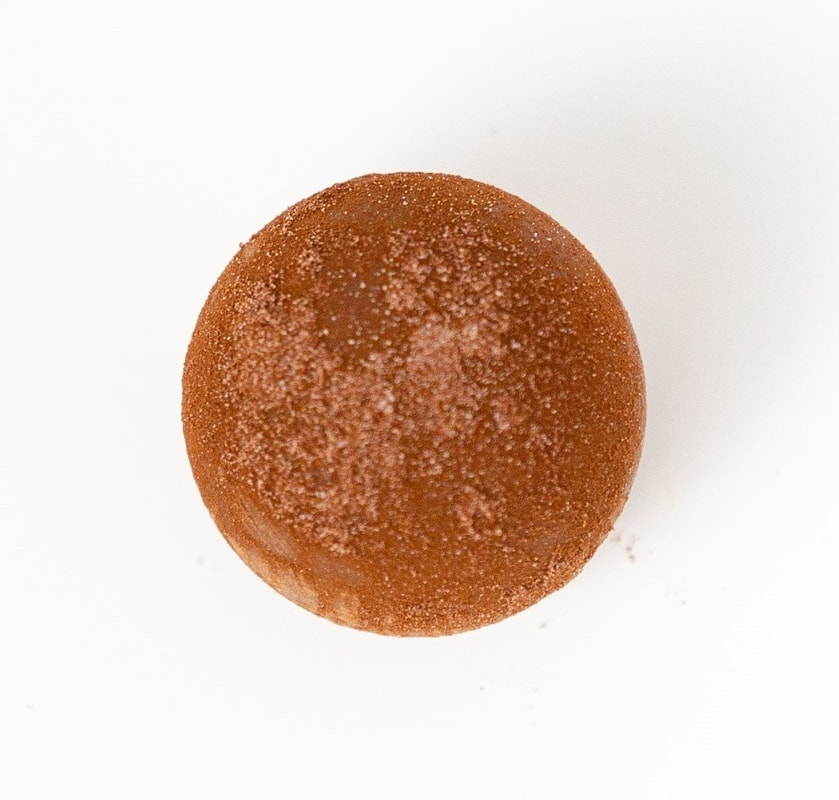 Round sugar-dusted brown pastry on a white background