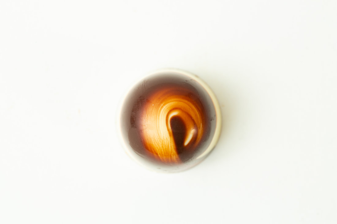 Close-up of a glowing orange light seen through a small circular opening on a white background