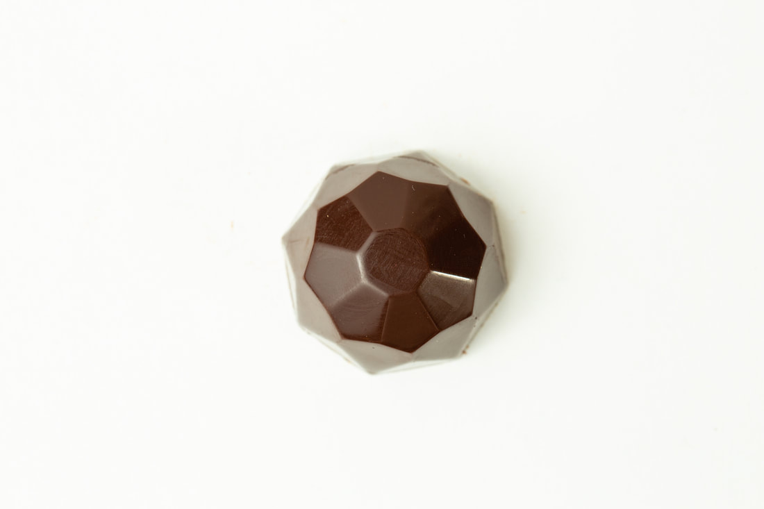 Small faceted brown gemstone on a white background