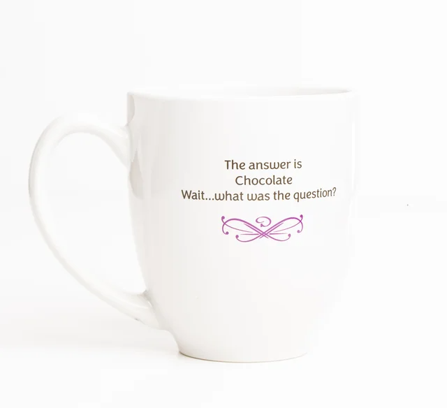 White mug with the text “The answer is Chocolate. Wait…what was the question?” and a pink flourish.