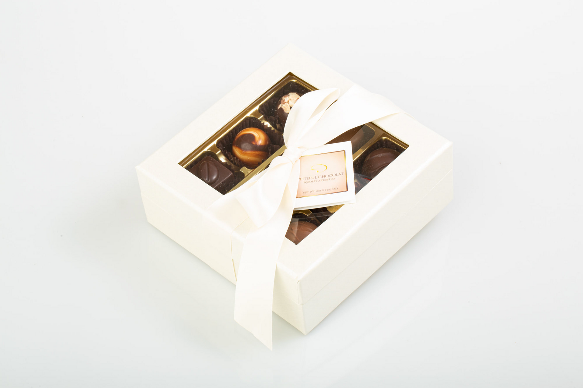 Open box of assorted chocolates in a cream-colored gift box