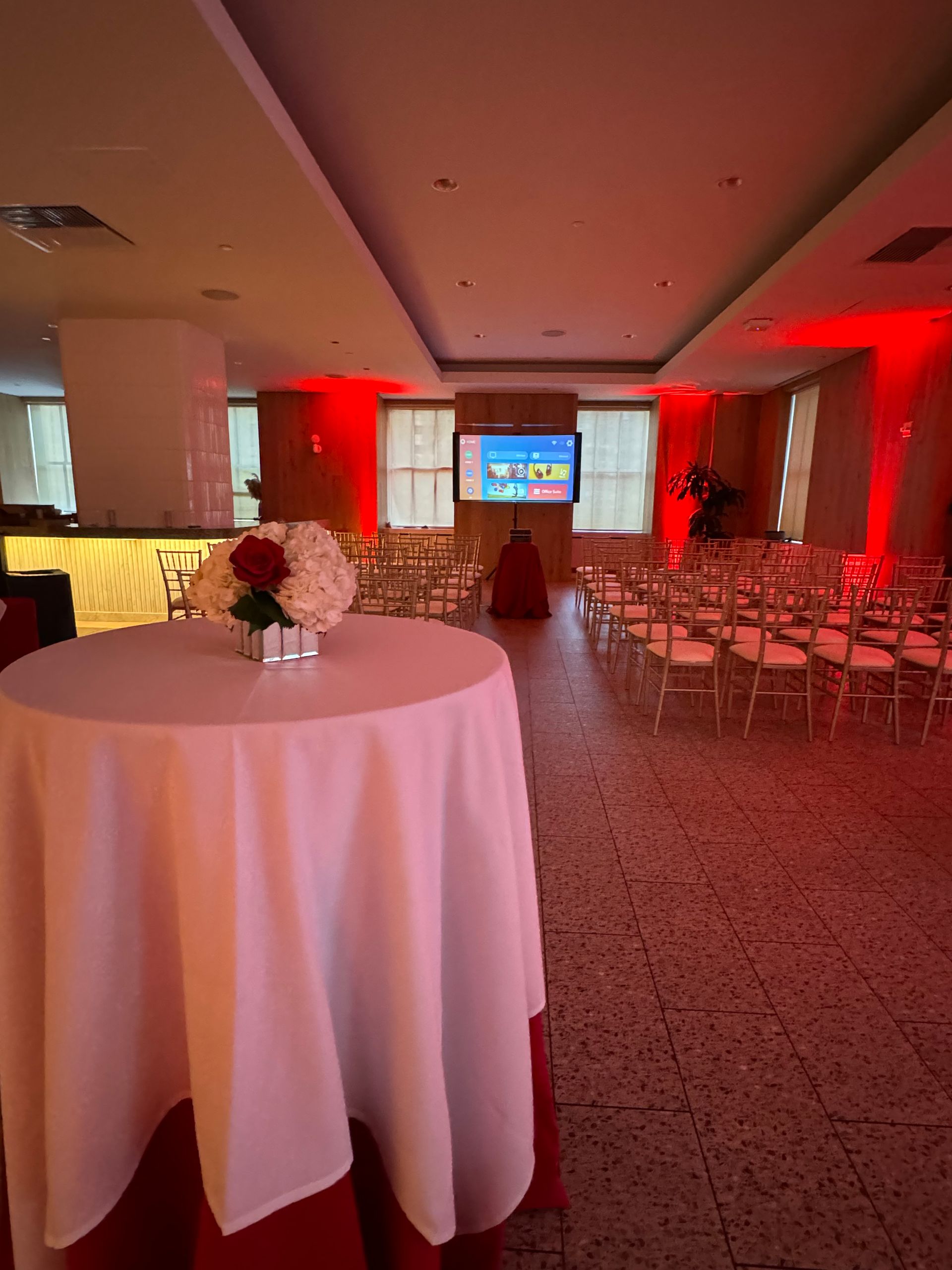 A room with rows of chairs and a table with flowers on it