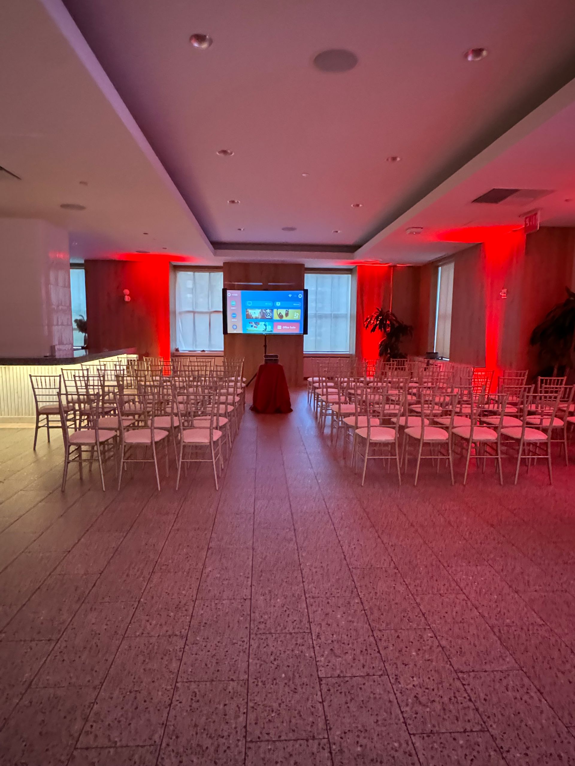 A large room with rows of chairs and a flat screen tv.