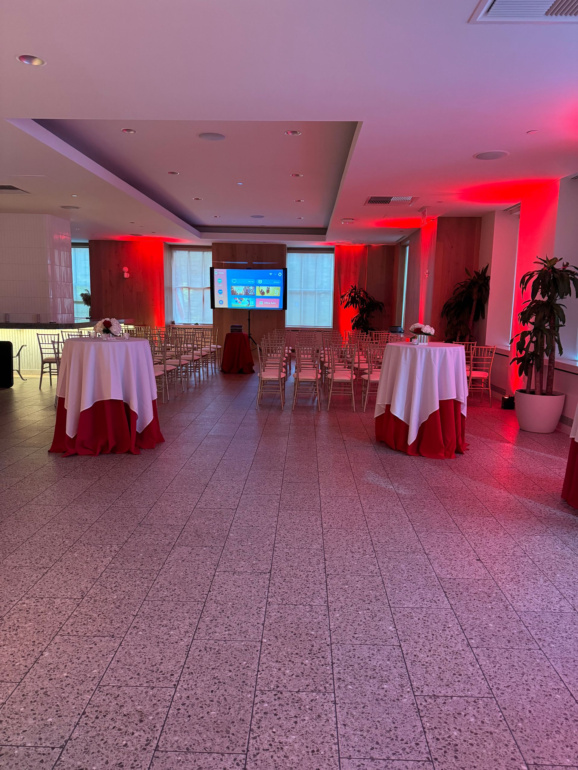 A large room with tables and chairs set up for a party.