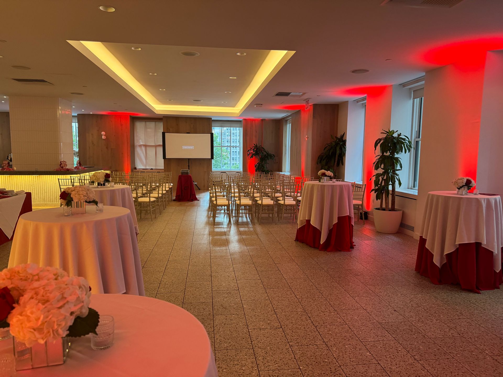 A large room with tables and chairs set up for a party.