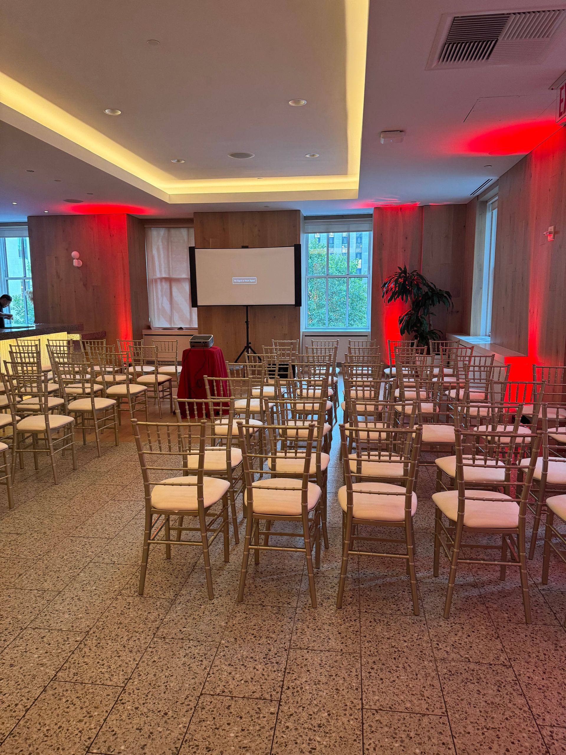 A large room with rows of chairs and a projector screen.
