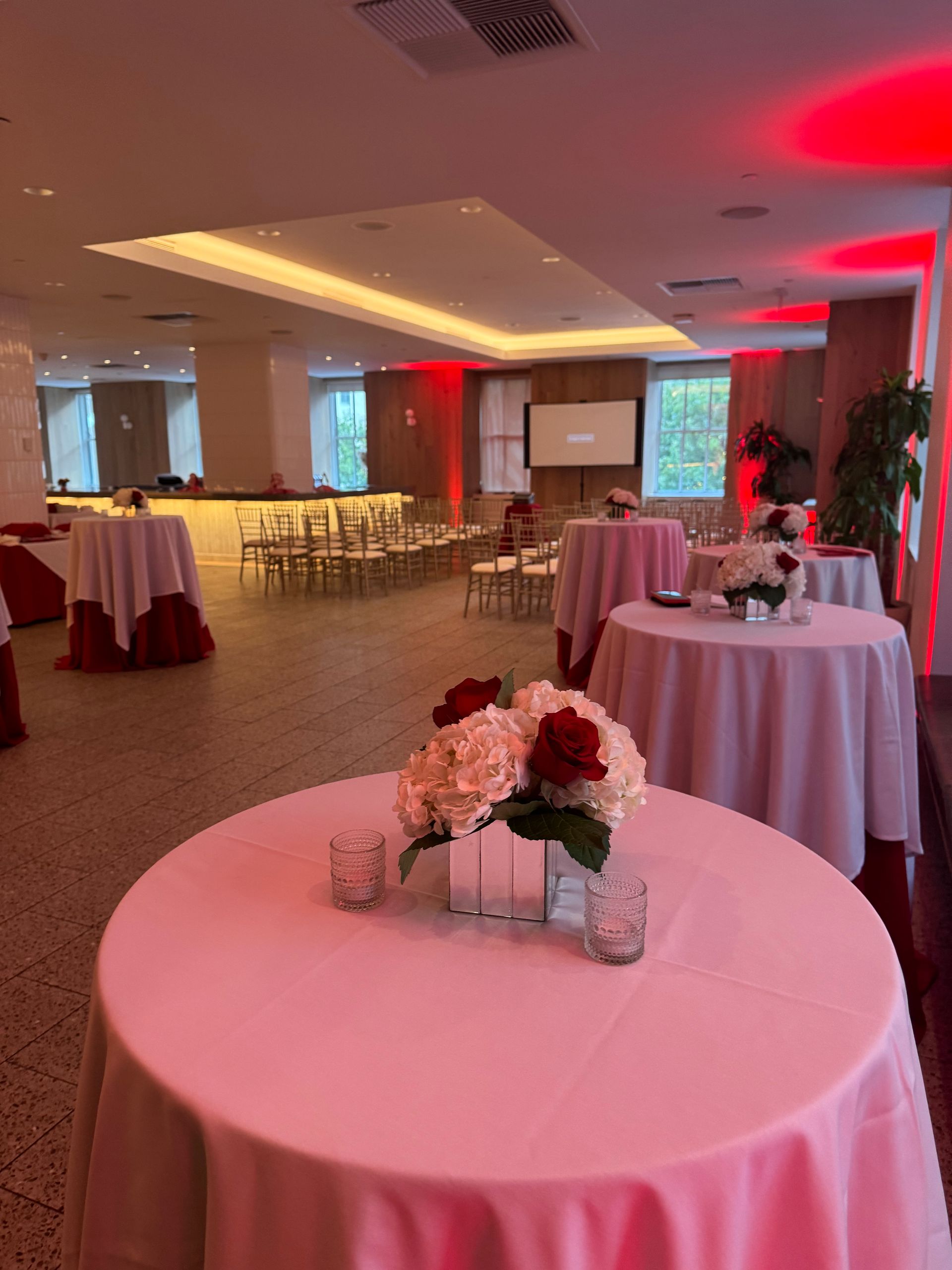 A large room with tables and chairs set up for a party.