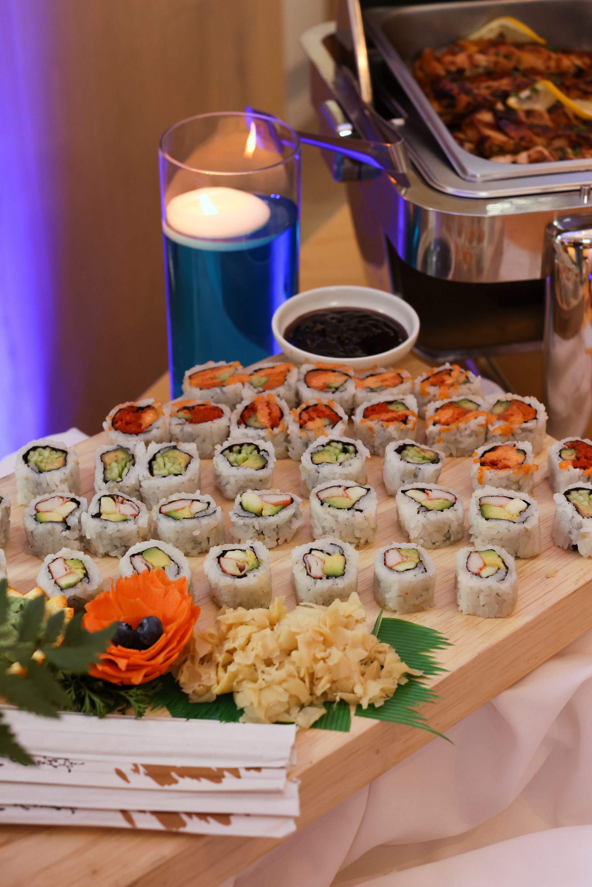 EQX City Catering Event Space at Rockefeller Center - A table topped with a variety of sushi rolls and a candle.