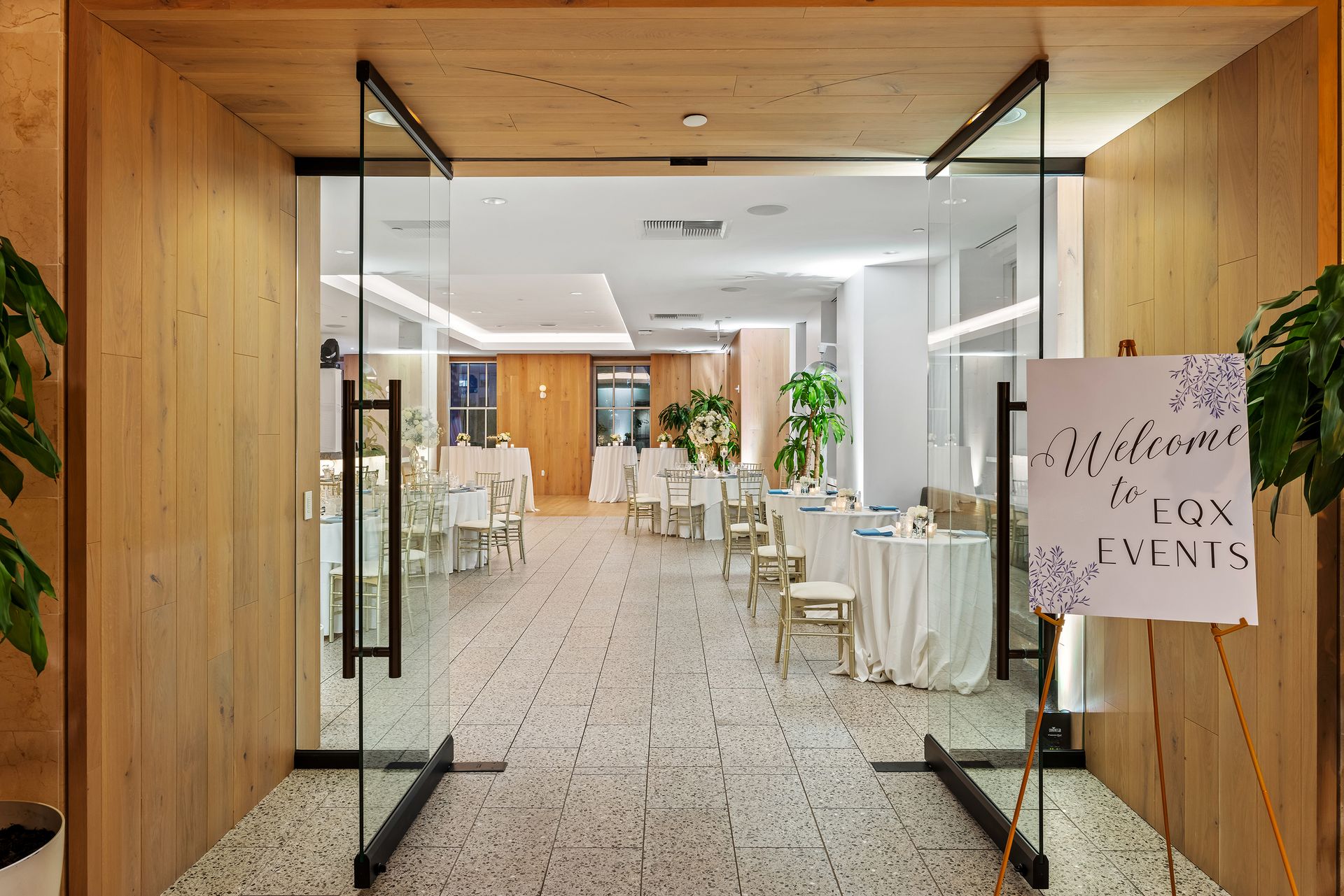 EQX City Catering at Rockefeller Center. A restaurant with tables and chairs and a sign in front of it.