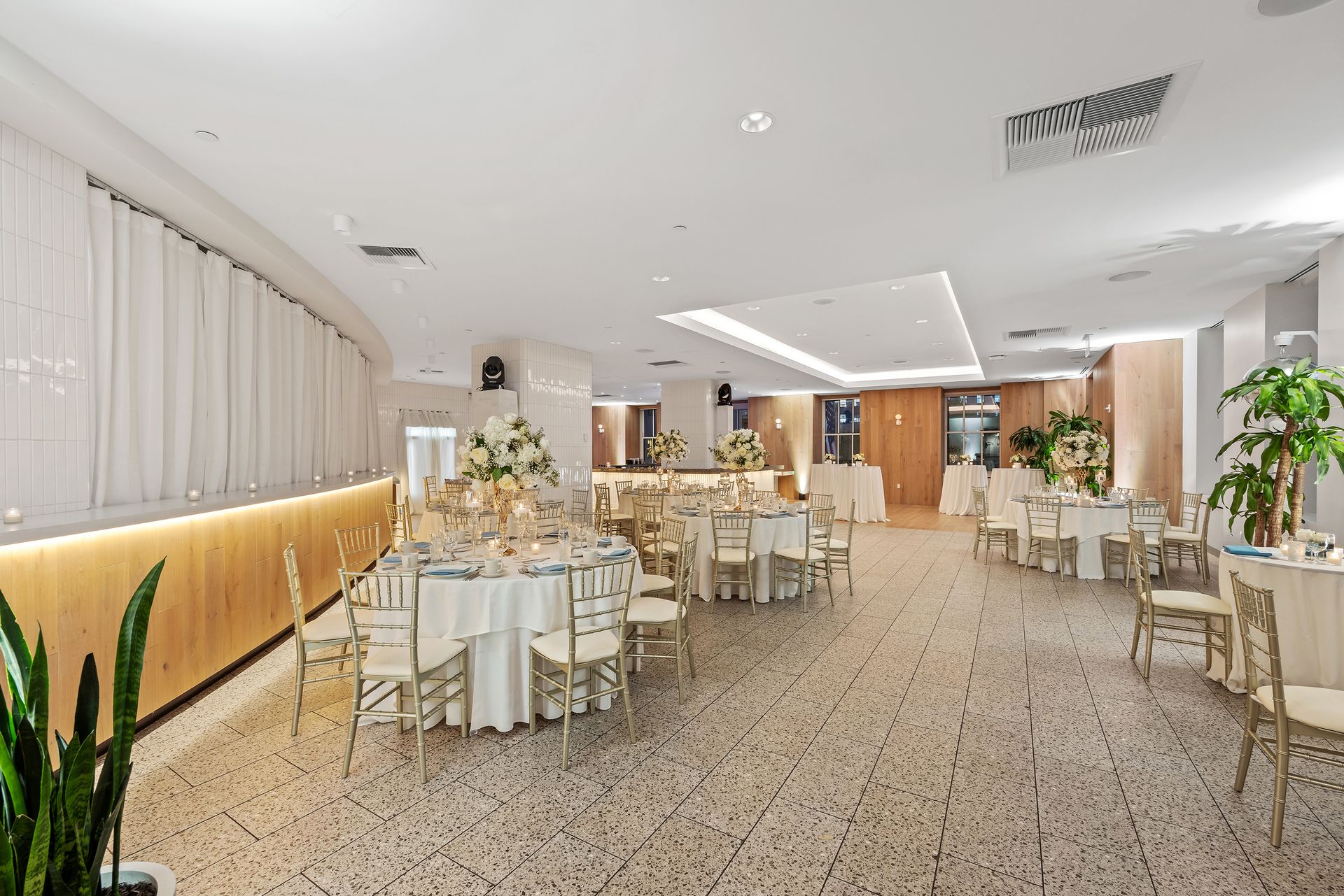 EQX City Catering at Rockefeller Center. A large room with tables and chairs set up for a wedding reception.