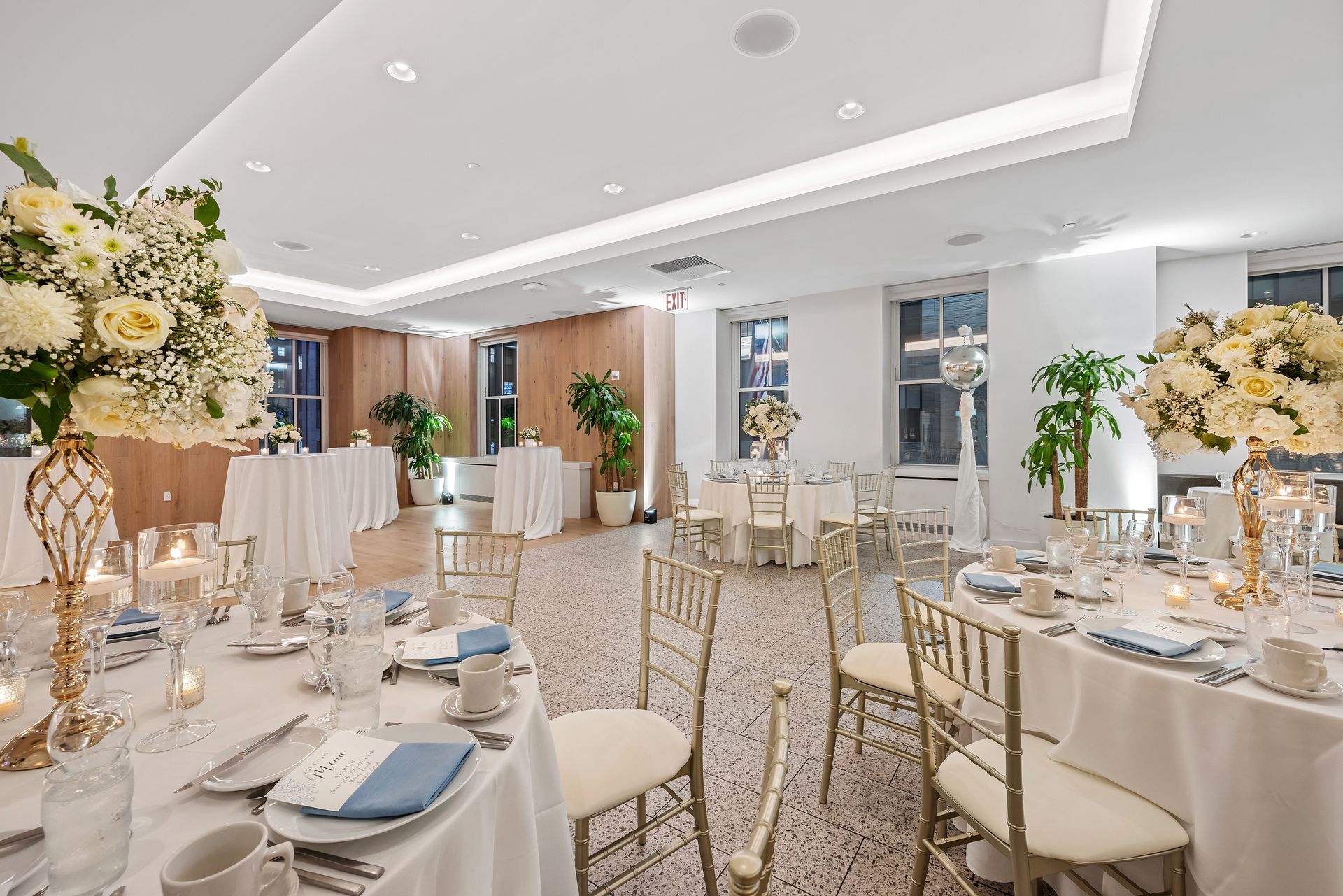 A large room with tables and chairs set up for a wedding reception.