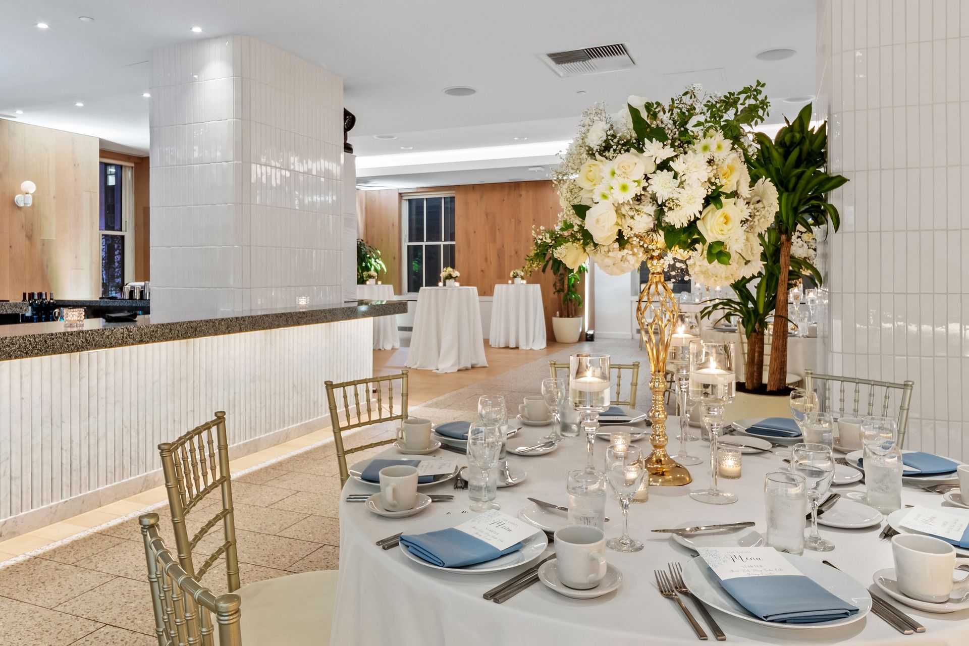 EQX City Catering at Rockefeller Center. A table set for a wedding reception with a vase of flowers on it.