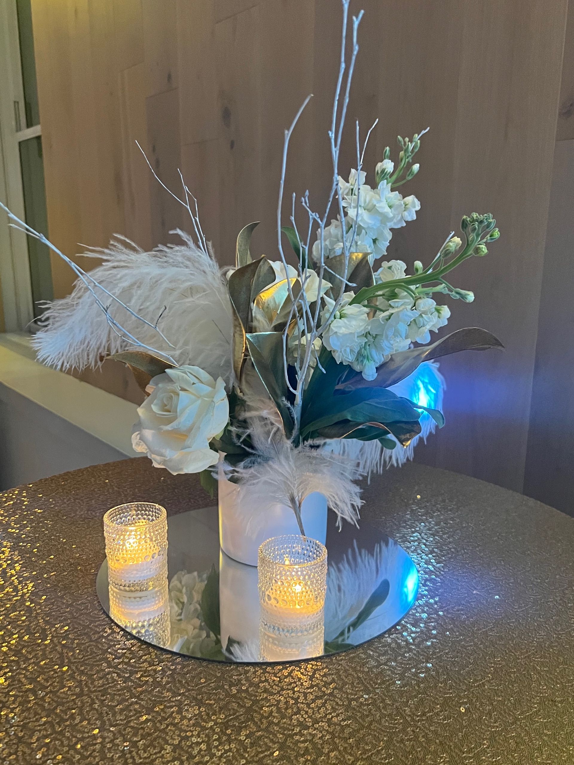 EQX City Catering Event Space at Rockefeller Center -  vase filled with white flowers and feathers is sitting on a table.