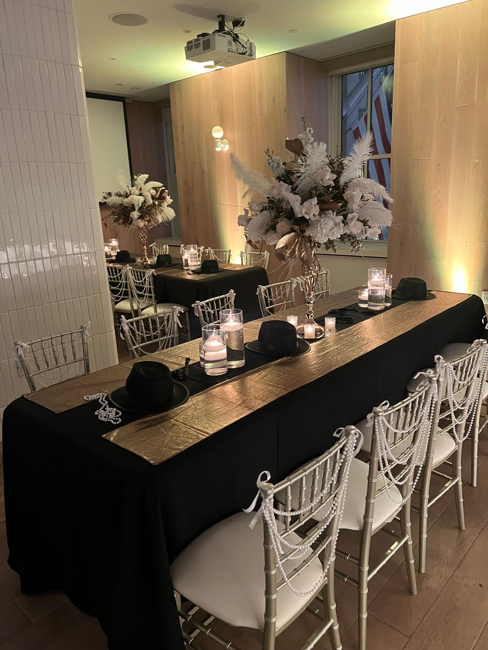 EQX City Catering Event Space at Rockefeller Center - A long table with chairs and flowers on it in a room.