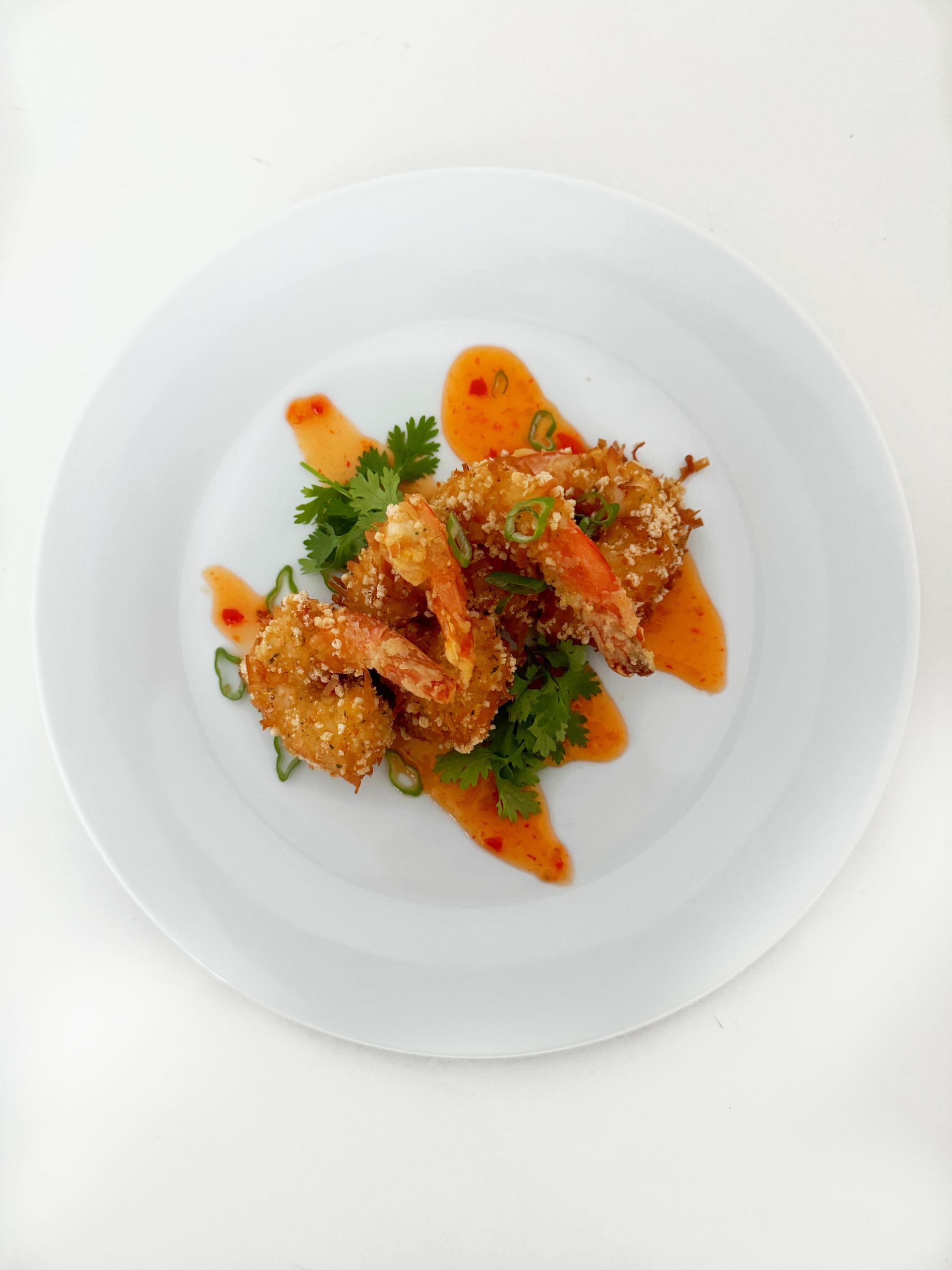 EQX City Catering Event Space at Rockefeller Center - A white plate topped with fried shrimp and sauce