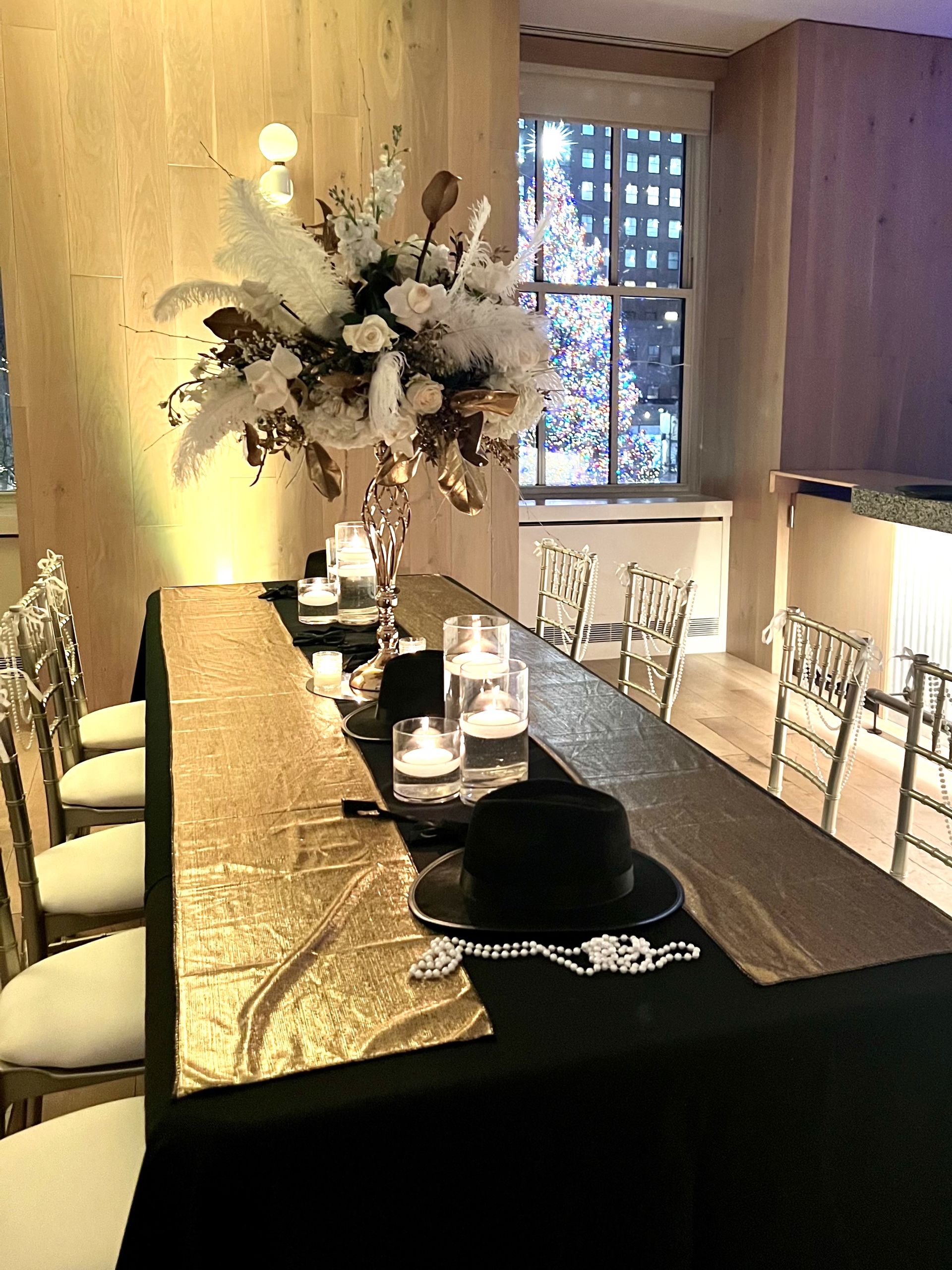 EQX City Catering Event Space at Rockefeller Center - A long table with plates , glasses , and flowers on it.