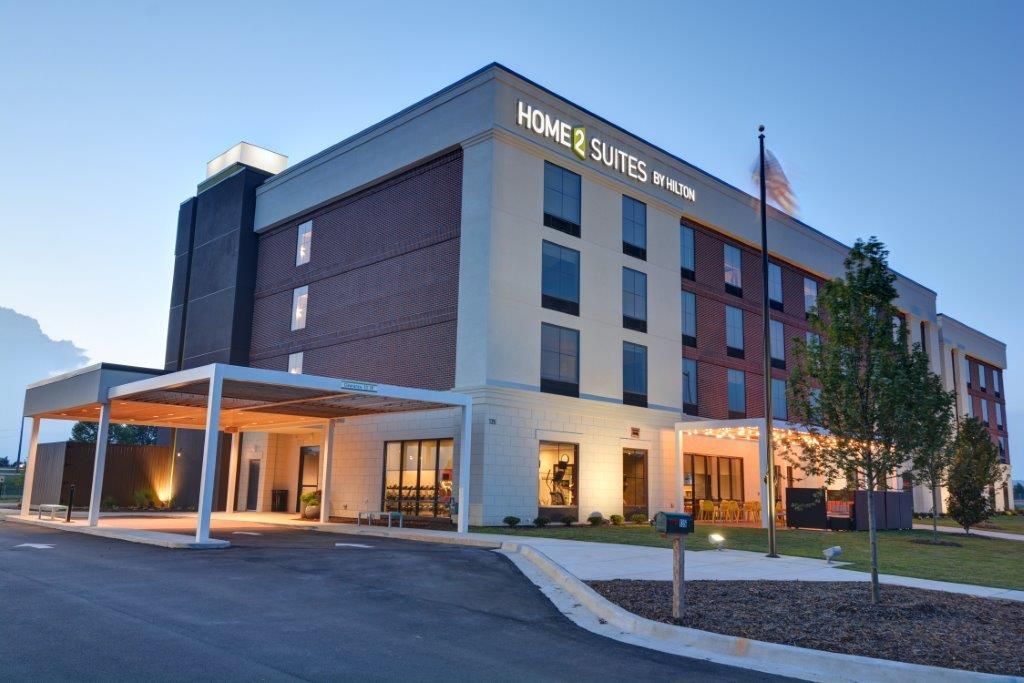 Hotel Super 8 exterior at dusk with illuminated entrance and parked cars