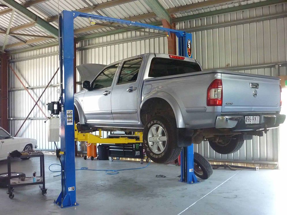 Silver Pickup Truck Raised on a Blue Vehicle Lift — Fischer Automotive in Svensson Heights, QLD
