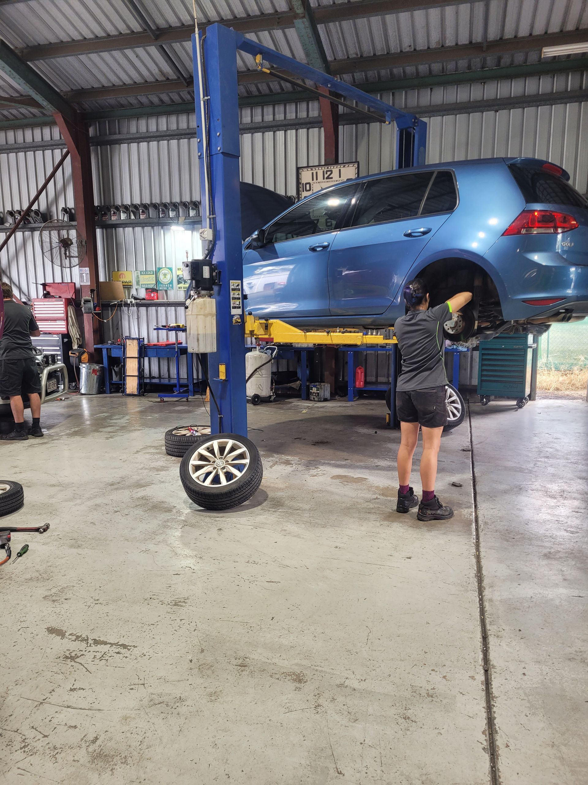 Blue Car Lifted on a Garage Hoist While a Mechanic Works — Fischer Automotive in Svensson Heights, QLD