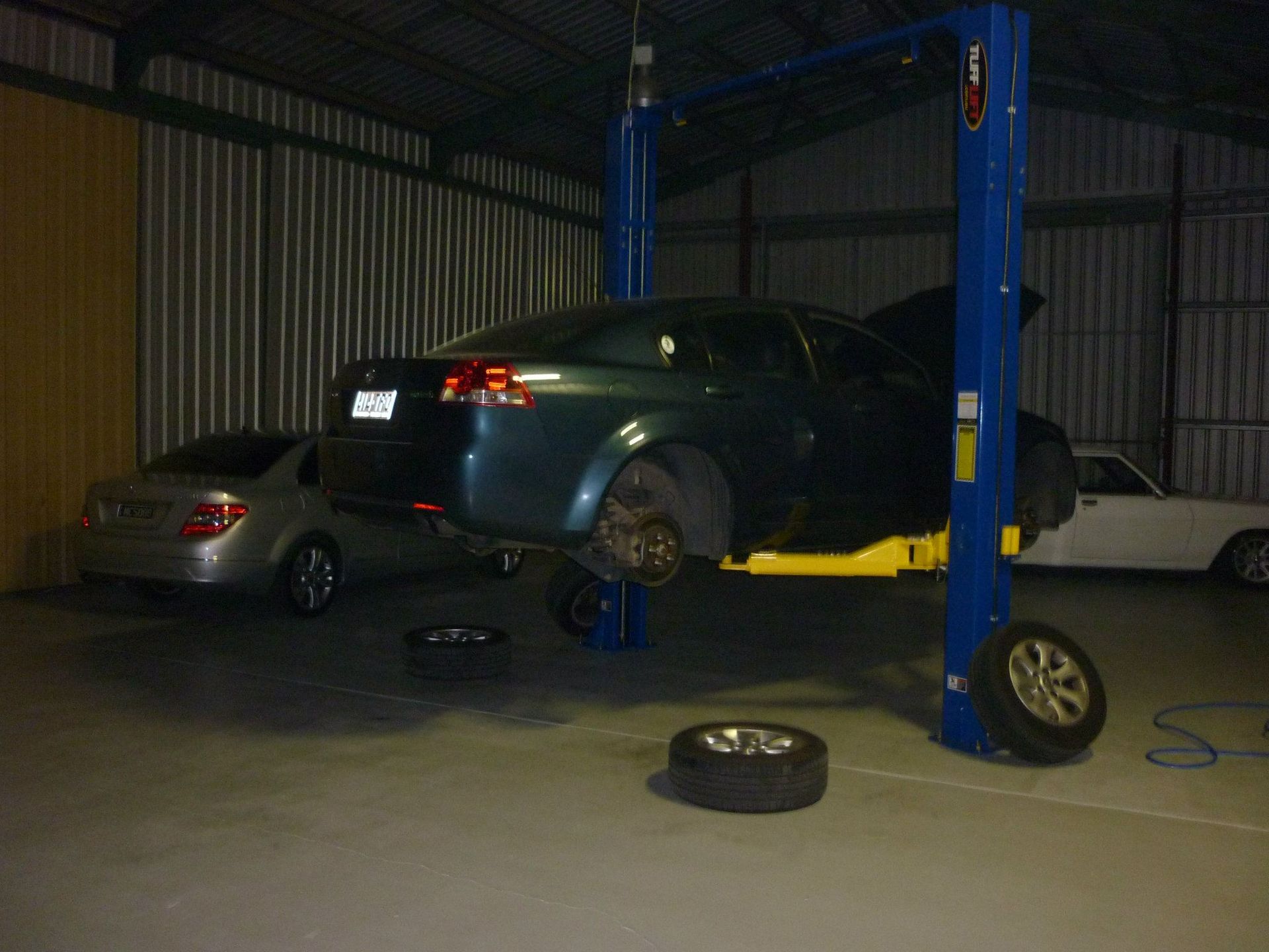 Car on a Lift in a Dim Garage — Fischer Automotive in Svensson Heights, QLD