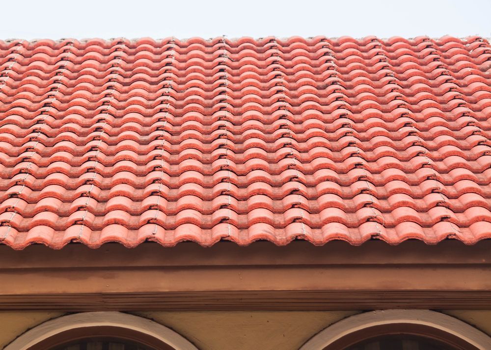 A Close Up of a Red Tiled Roof on a Building — RJT Roofing In Gungahlin, ACT