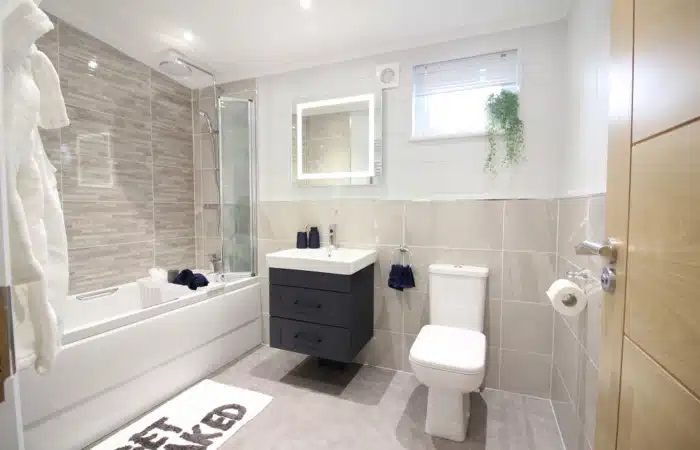 A bathroom with a toilet , sink and bathtub.