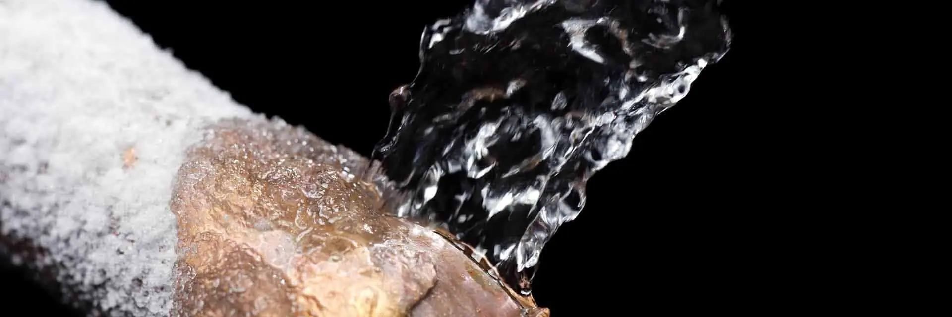 A close up of water splashing on a piece of wood on a black background.