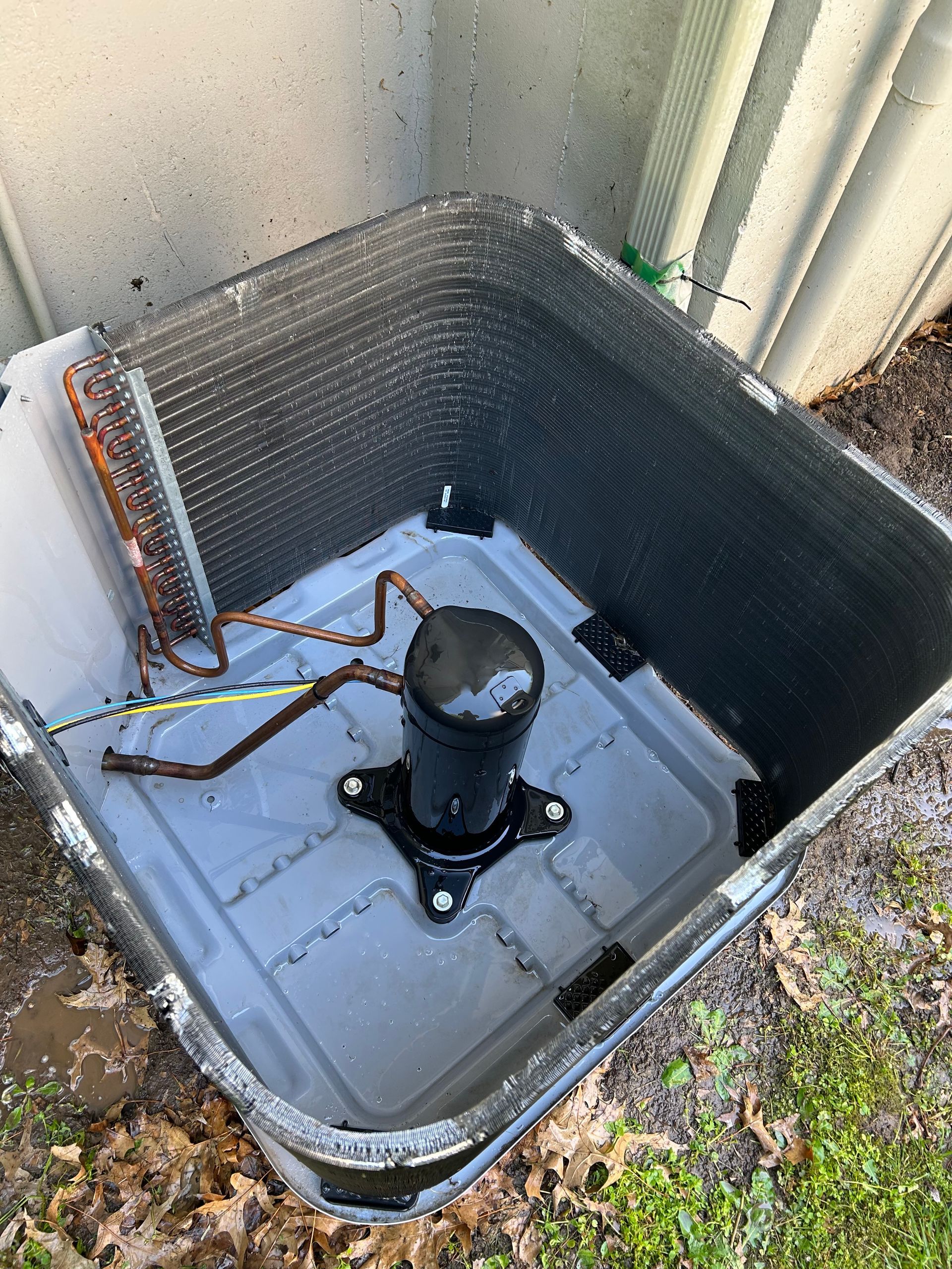 The inside of an air conditioner is sitting on the ground.