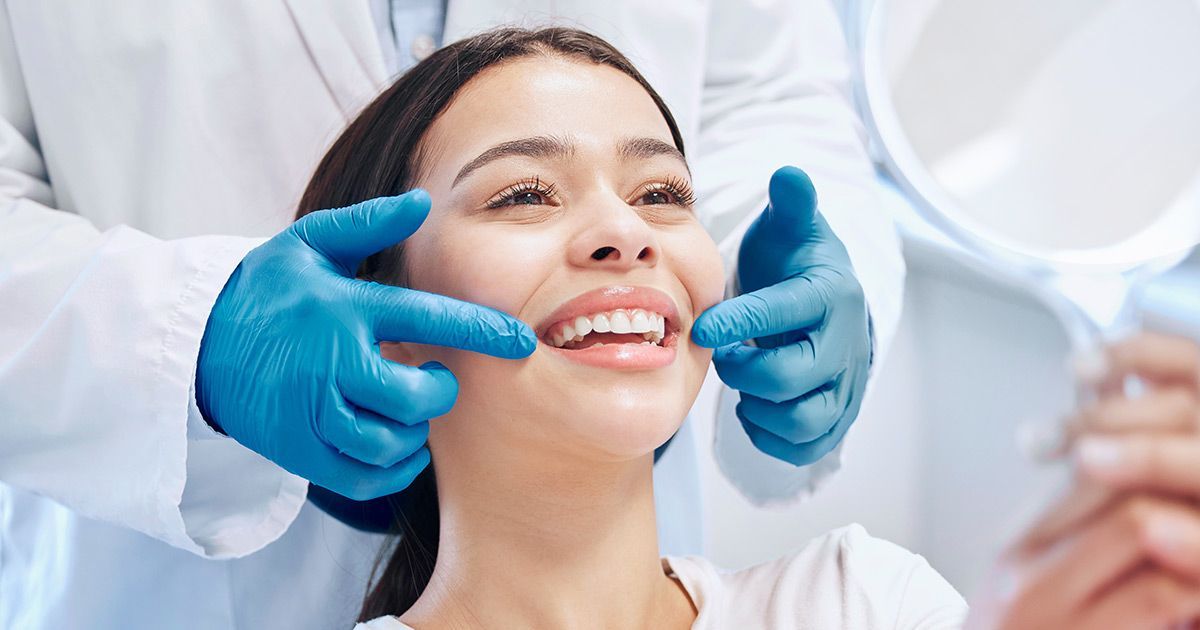 a woman is getting her teeth examined by a dentist .